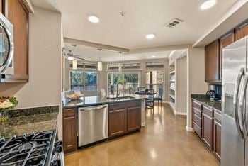 A modern kitchen with a large island and stainless steel appliances.